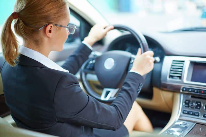 Woman behind the wheel of a rental car prepared for daily commuting or rideshare driving